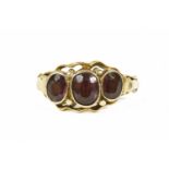 A gold three stone garnet ring, all rub set to split shoulders tested as approximately 22ct gold)2.