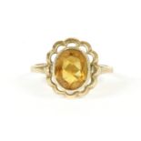 A 9ct gold single stone citrine ring, rub set to a scalloped border and plain polished shank, size