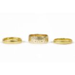 Two 22ct gold wedding rings, size N and L, and a 9ct gold wedding ring with engraved decoration,