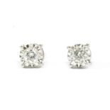 A pair of white gold single stone diamond stud earrings, with a brilliant cut diamond, illusion