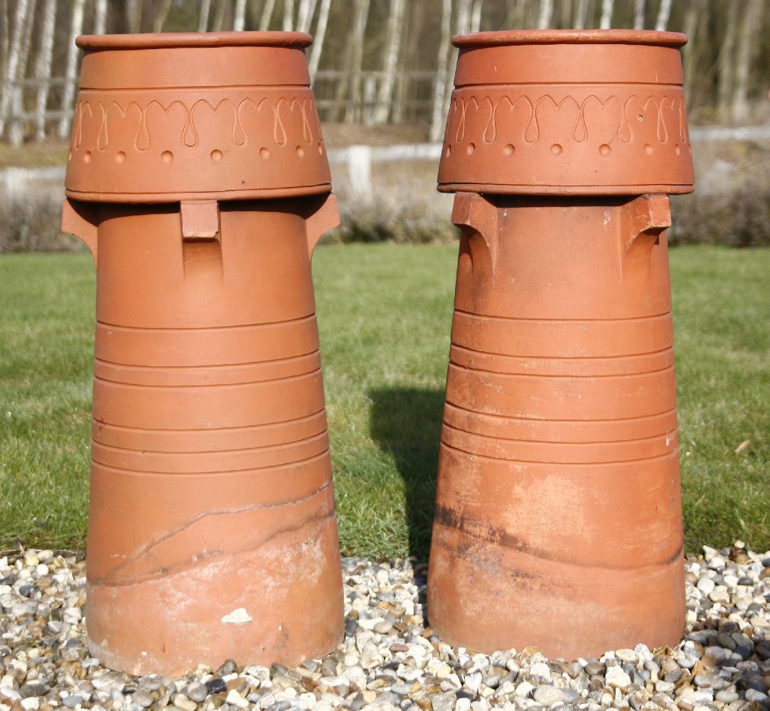 A pair of Edwardian terracotta chimney pots wit decorated vents, 32cn diameter 76cn high