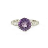 A silver single stone circular cut amethyst ring, with cubic zirconia pavé set shoulders2.93g