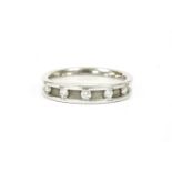 A platinum five stone diamond half eternity ring, with a row of evenly spaced brilliant cut