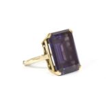 A gold single stone emerald cut synthetic colour change sapphire ring, (tested as approximately
