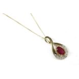 A gold ruby and diamond pendant, with an oval mixed cut ruby, claw set to a graduated figure of