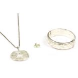 A pair of gold opal cabochon stud earrings, a silver hinge bangle with engraved top section, and a