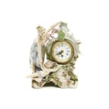 An early 20th century Continental porcelain clock, with a lady, a cherub and flower encrustation,