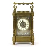 A French brass repeating carriage clock, the body with four fluted pillars and the face enamelled