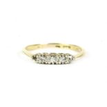 A gold five stone graduated diamond ring, marked 18ct and PLAT, one stone deficient, finger size O½,