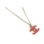 A Chanel pink enamel interlocking double 'C' pendant necklace, with a gold plated chain, and a