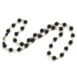 A single row uniformed round shaped onyx and Baroque shaped cultured pearl necklace, with 9ct gold