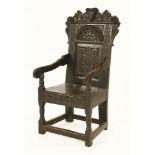 An oak wainscot armchair,late 17th century, the top rail centred with a shield, flower heads and