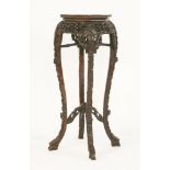 A Chinese hardwood octagonal jardiniere stand,c.1880, with a rouge marble top, profusely carved,