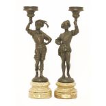 A pair of figural bronze candlesticks,each holding aloft candle sconces, inscribed 'SOHER 142/