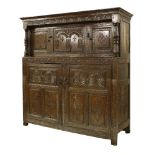 An oak press cupboard,17th century and later, carved with lunette, guilloché and incised decoration,