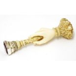 A Victorian ivory seal,c.1870, intricately carved as a delicate hand gripping the shaft below a