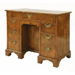 A George II walnut kneehole desk, with herringbone banding, the rectangular top over a long frieze