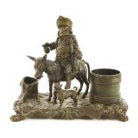 A bronze desk stand,19th century, formed as an inebriate riding home on a donkey, his dog beside