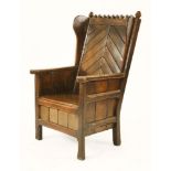 An oak armchair,with an arcaded top, raised diagonal carved panelled back and seat, with panelled