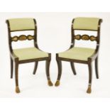 A pair of Regency ebonised chairs,with painted gilt decoration, carved shell bars and sabre legs