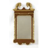 A George II-style mahogany and parcel gilt wall mirror,with a scrolled crest over a shaped