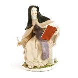 A Chelsea porcelain figure of a nun holding a book, and also holding a quill, with inscription '
