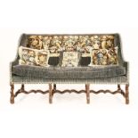 A Louis XIV walnut sofa,18th century, upholstered with 17th century tapestry panels, on a blue