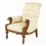 A Victorian mahogany library armchair, the arms having carved dog's head terminals, over scroll