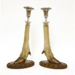 A pair of silver-plated candlesticks,20th century,mounted on an antelope leg, raised on a carved