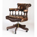 A modern mahogany swivel office chair in the Victorian style,with deep buttoned brown leather