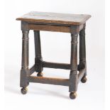 An oak joined stool,17th century and later, on turned supports and wooden castors,52cm high