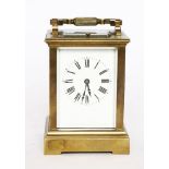 A brass carriage clock,with an enamel dial, the repeating mechanism striking the hours and half