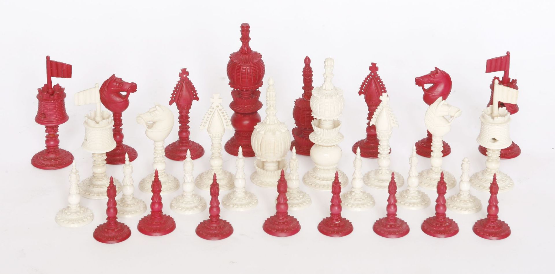 A Chinese ivory chess set,mid-19th century, with engine turned and carved decoration, red stained