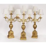 Three giltwood and cast metal, two-branch, three-light, table lamps,20th century, with leaf-