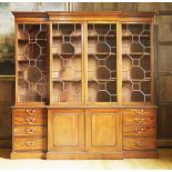 A reproduction mahogany breakfront bookcase,in the George lll style, the moulded cornice over four