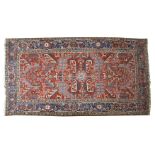 An Heriz carpet, North-West Persia, the brick red field with a central medallion within an indigo