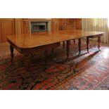 A mahogany extending dining table,early 19th century, with five extra leaves, the shaped moulded top