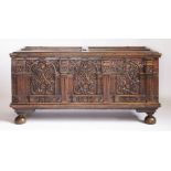 A walnut cassone,1644, the hinged panelled top with a central escutcheon to a large and ornate