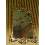 A George II-style giltwood wall mirror,18th/19th century, the frame crisply carved with rocaille and