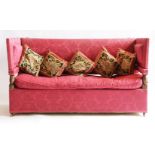 A Knole settee,first half of the 20th century, upholstered in scarlet damask, the padded arms on