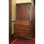 A George III mahogany bureau bookcase,the dentil cornice over a blind fret frieze and two panelled