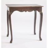 A country oak side table,mid-18th century, the plank top over a scrolled frieze and square