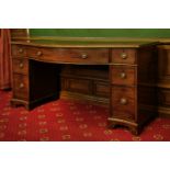 A George III mahogany serpentine sideboard,the top with a moulded and leaf-carved border, above a