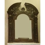 A large and ornate Victorian oak overmantel mirror,the broken arched top crisply carved with a