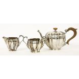 A three piece tea set, Birmingham, 1928, with matching tongs, teapot 13.5cm high