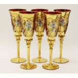 A set of five red glasses, with gilt overlay and applied flowers. 23cm high.