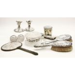 A pair of dwarf silver candlesticks, loaded, a silver cigarette box and dressing table items