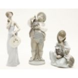 Three Lladro figures, including a young girl with a kitten and a puppy, a man with a wine bag, and a