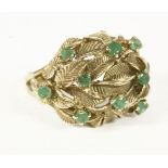 A 9ct gold emerald set leaf design bombé shaped ring 7.29g