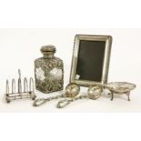 Silver items to include a filigree mounted glass bottle with hinged lid, London 1902, a photo frame,